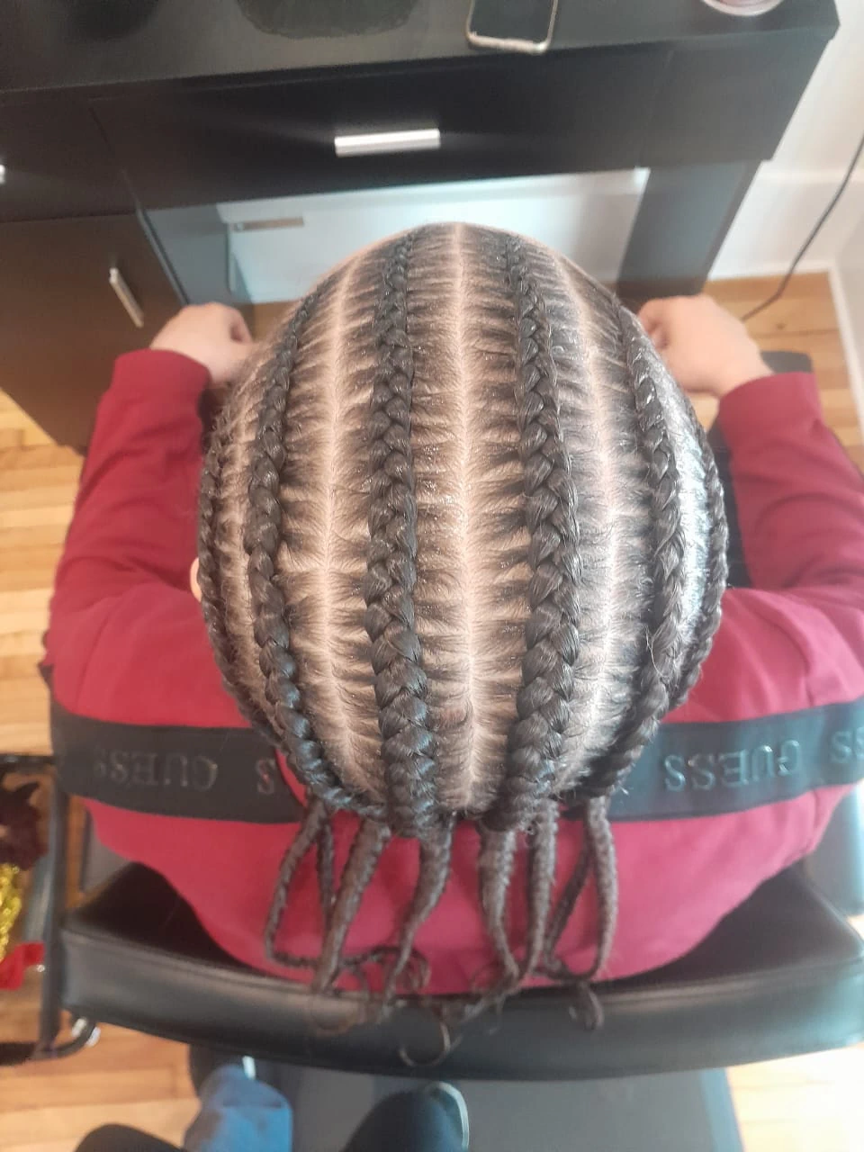 Top view of a man with clean, straight-back cornrows, demonstrating professional grooming and healthy hair care for men.