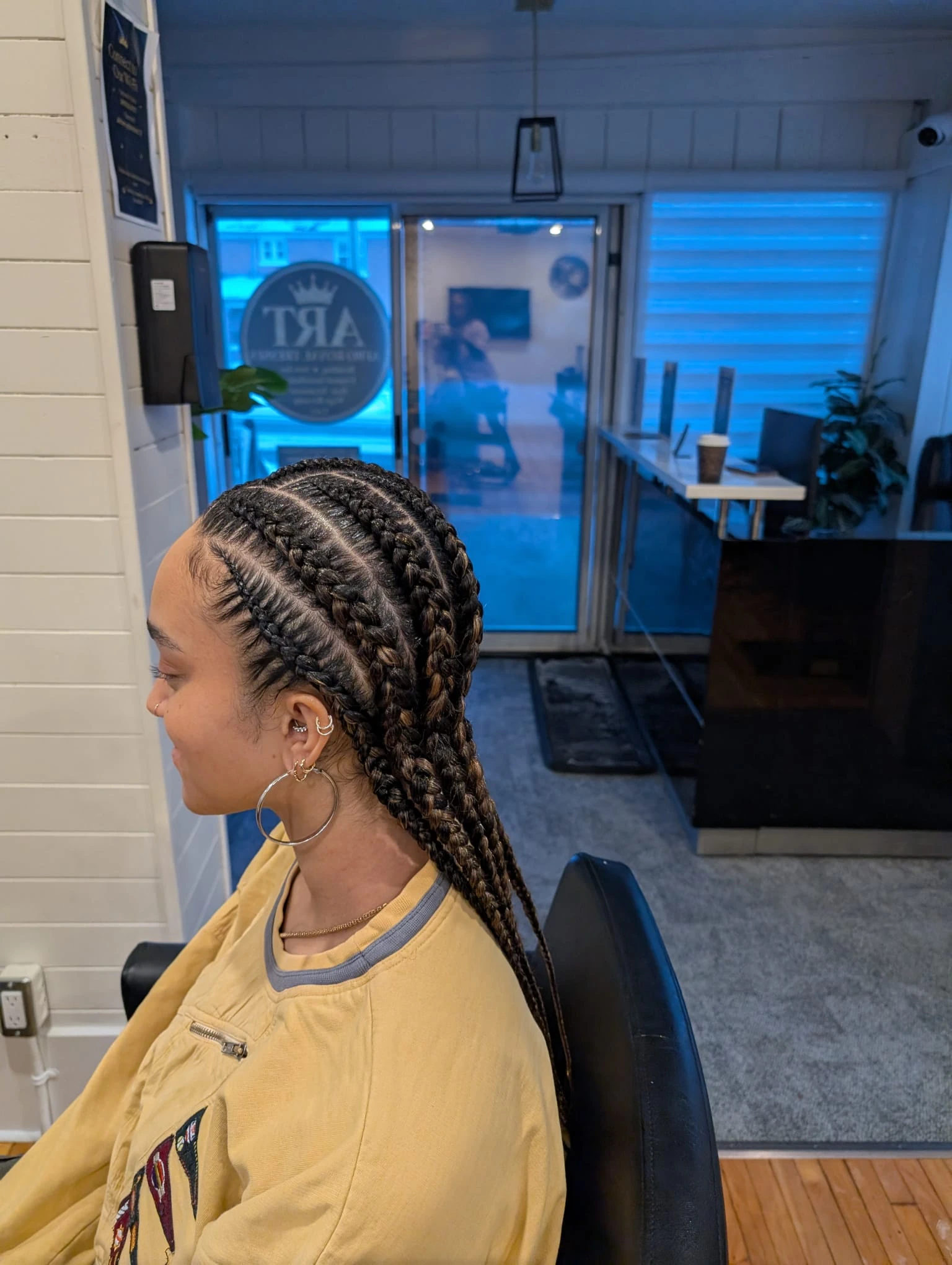 Side profile of a client wearing neat, straight-back feed-in cornrows, a long-lasting protective style expertly crafted at our Kitchener salon.