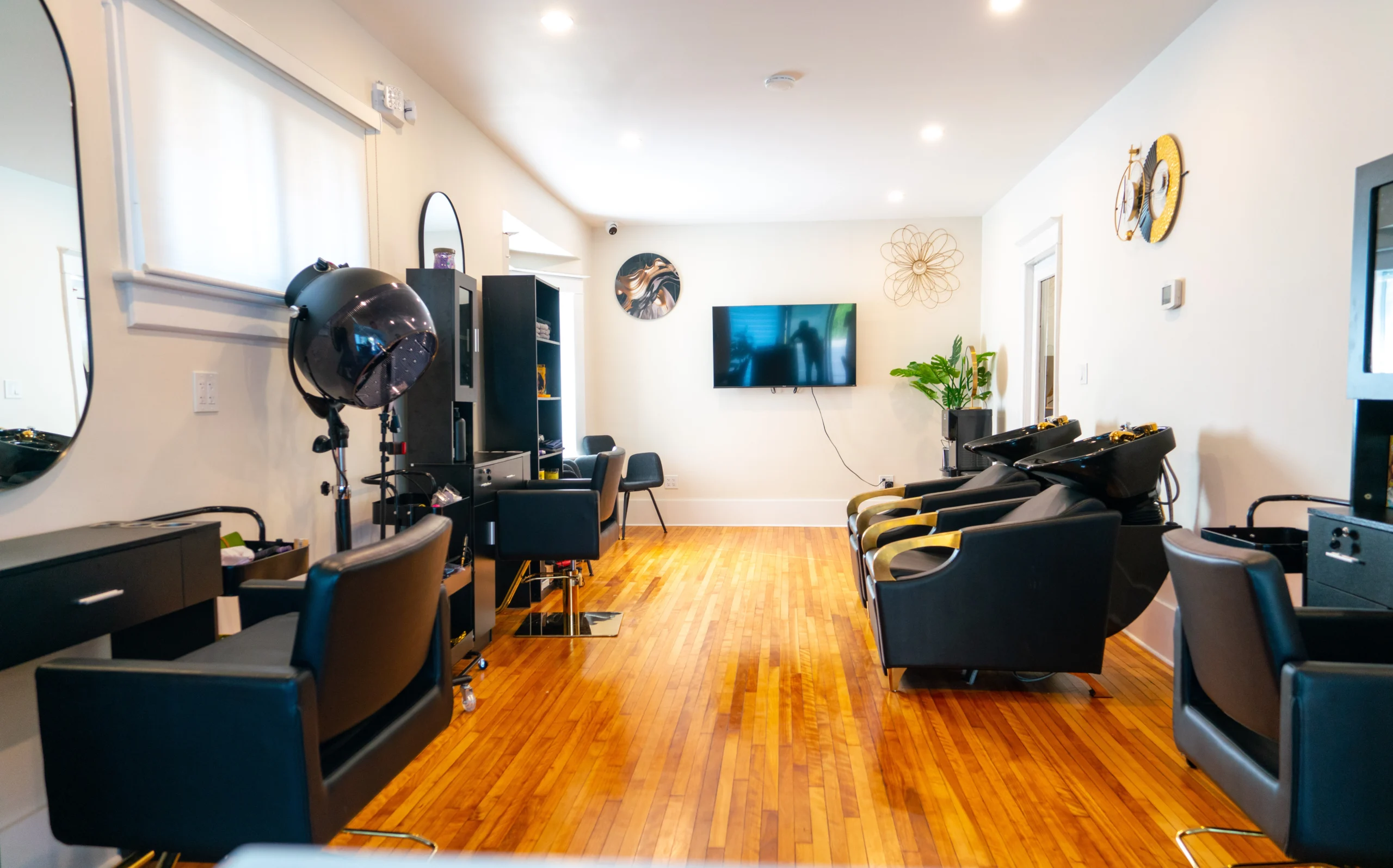 Wide interior shot of our upscale textured hair salon, showing comfortable styling stations, hardwood floors, and a welcoming atmosphere.